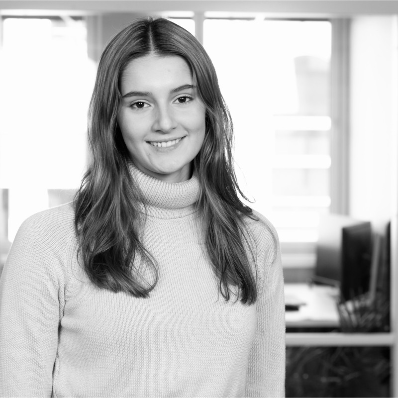 a black and white photo of a woman in a sweater.