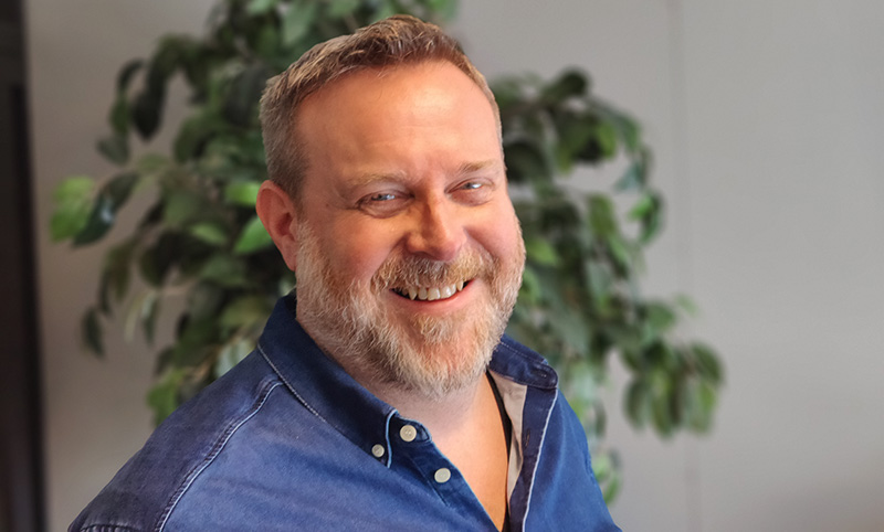 a man with a beard smiling at the camera.