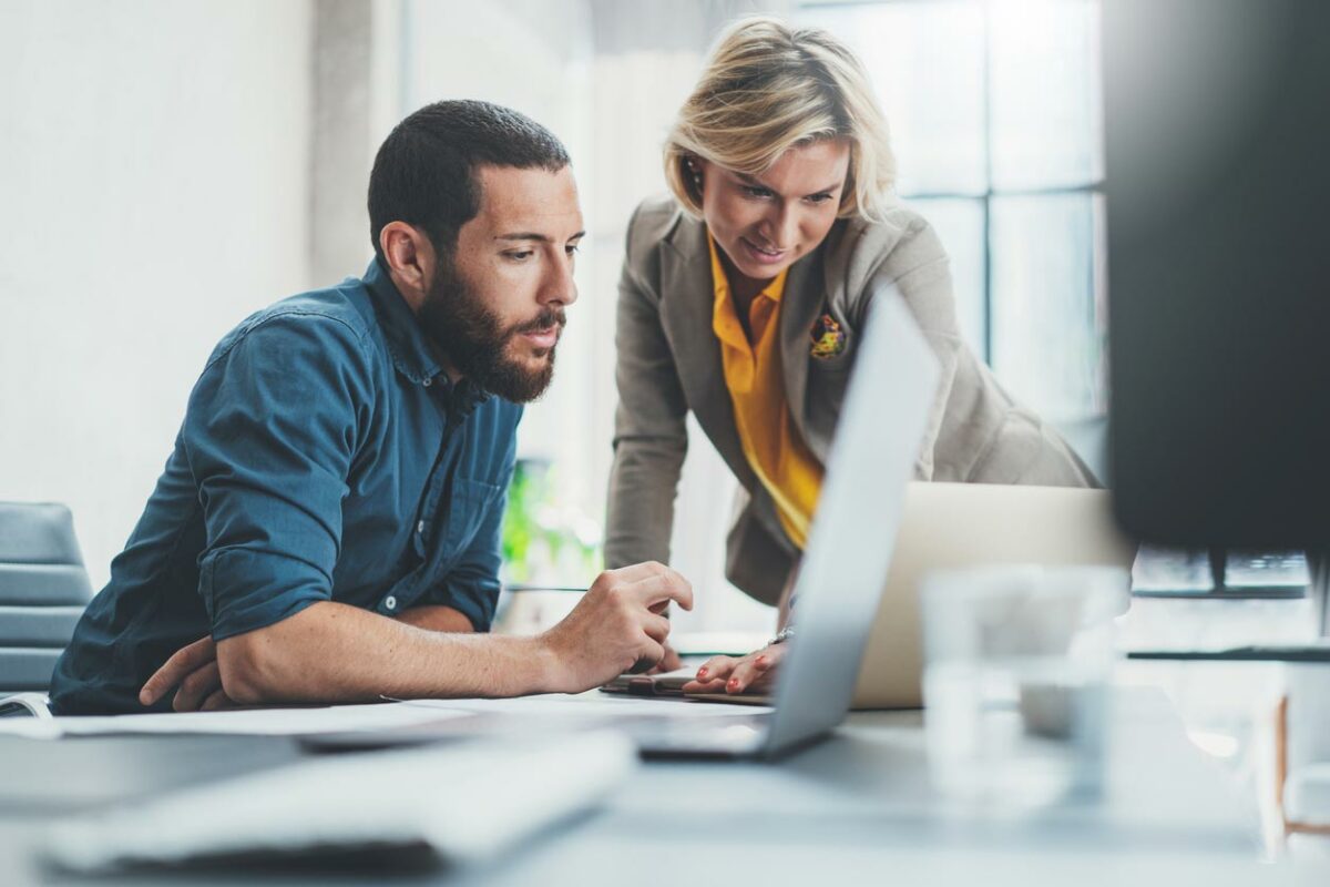 a man and woman looking at a computer screen.