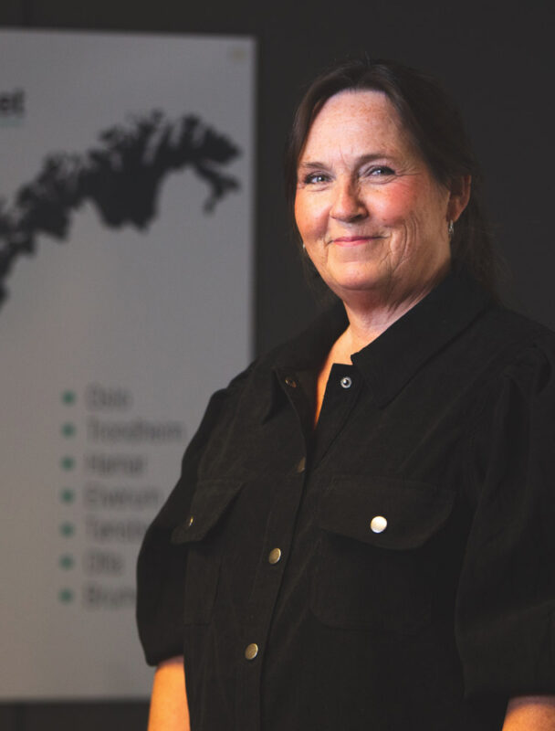 a woman standing in front of a poster.