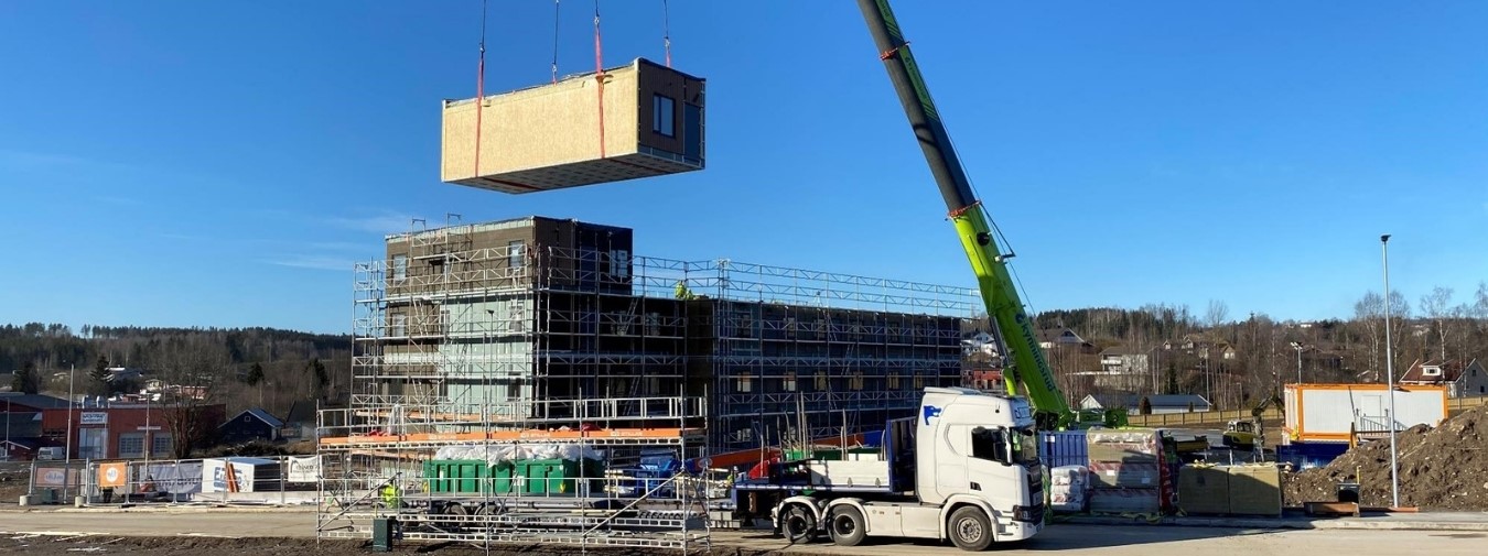 a crane is lifting a large building into the air.