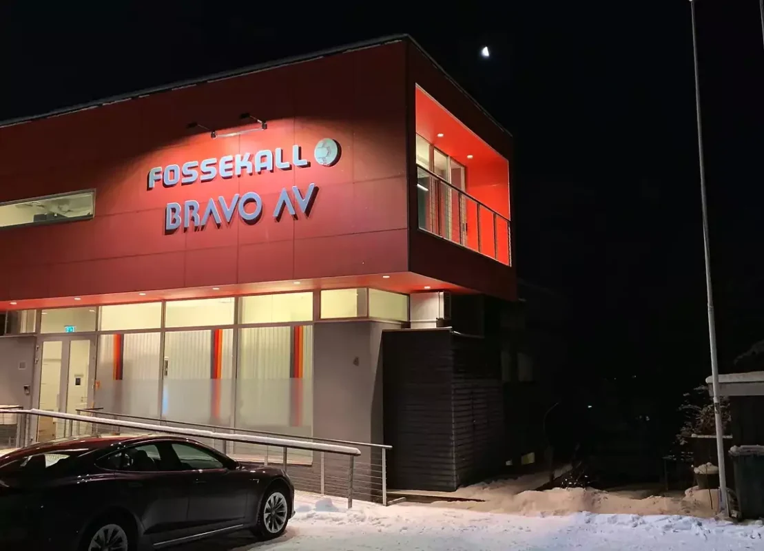 a car parked in front of a red building.