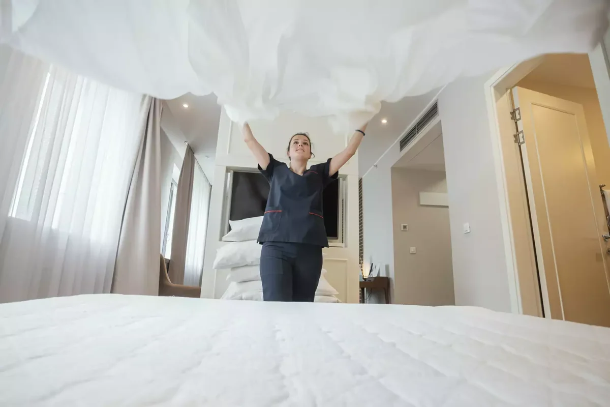 a woman standing on top of a bed in a bedroom.