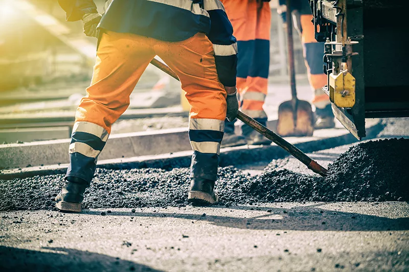 a man with a shovel is working on a construction site.