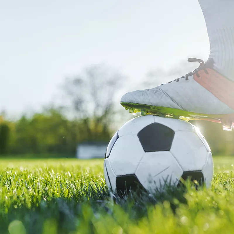 a person standing on top of a soccer ball.