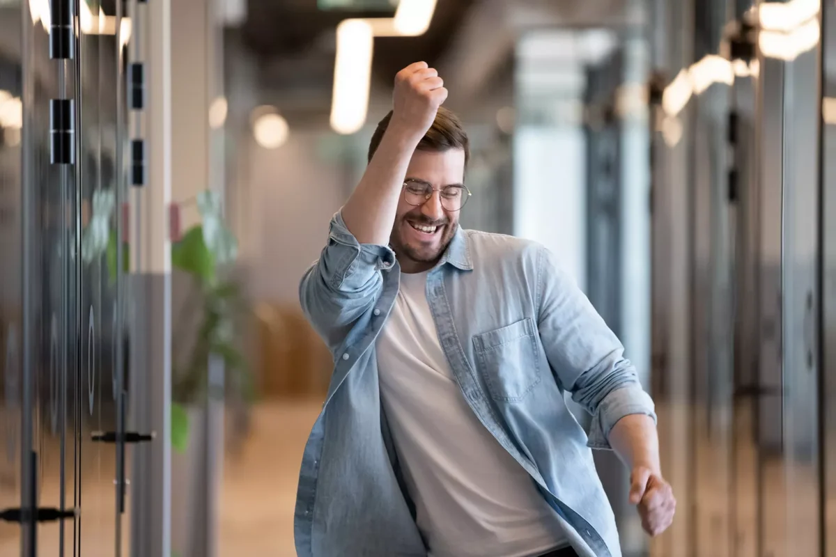 a man walking down a hallway with his hand in the air.