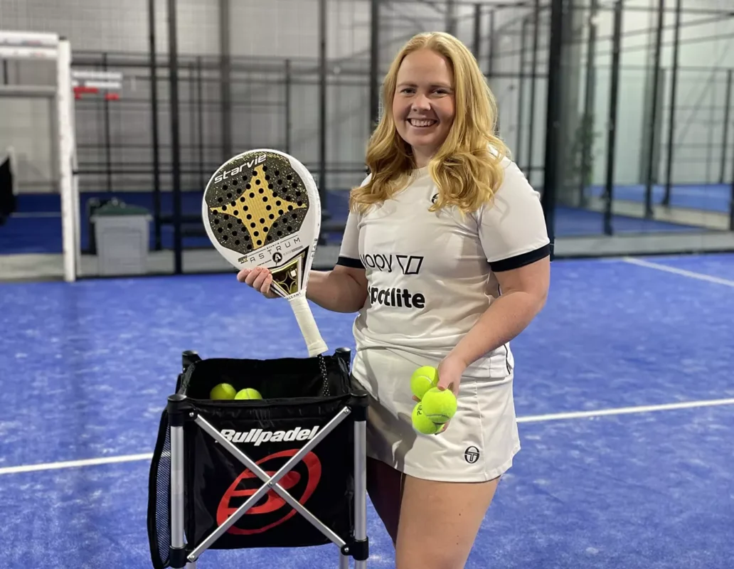 a woman holding a racket and tennis balls.